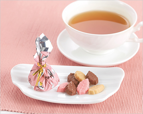 リーフメモリー桃色(250g入) 1,404円【限定1,120個】  桃色の巾着に包まれた小さな木の葉型のチョコレート。 フレーバー：クランベリー・キャラメル・ミルク