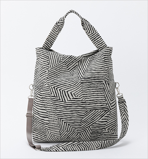 ワイヤードット3ウェイバッグ (ポリエステル・綿／裏地：ナイロン／W40×H37×D8cm) 20,900円  針金のようないびつなラインで構成された＜チャーム＞オリジナルジャカード生地を用いたシリーズです。 本体のハンドルを使用すれば肩掛けに、荷物が少ないときは二つ折りにしてショルダーバッグやクロスボディーバッグとして使用できます。A4ファイルが入るたっぷりとした収納力で、デイリーに活躍してくれます。 適度な光沢があり、シックな雰囲気が大人っぽく、カジュアルにもきれいめな装いにも合わせやすいバッグです。