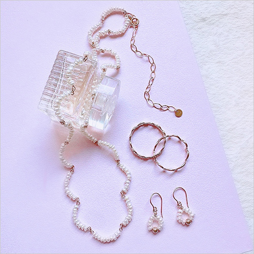 ネックレス(k14gf／淡水真珠) 77,000円 ピアス(k14gf／淡水真珠) 11,770円 リング(左)(k10) 37,950円 リング(右)(k10) 37,950円  カジュアルからフォーマルまで幅広いスタイルに調和するデザインに、ほんの少しの遊び心を添えたアクセサリーの数々をご紹介いたします。