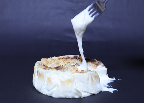 トロリとのび～るラクレットチーズケーキ(1ホール／直径12cm) 4,800円  とろ～り伸びるラクレットチーズで作った新感覚チーズケーキ。室温で少し緩めるとさらになめらかに伸び、そのままでもフルーツにかけても、ラクレットの濃厚な旨味をお楽しみいただけます。