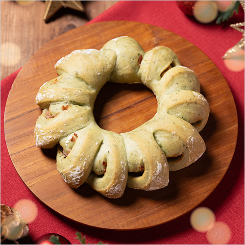 バジルリース(1個) 540円  バジルとチーズが香るジェノベーゼソースを練り込んだフランスパンでベーコンを包み、リース型にしました。