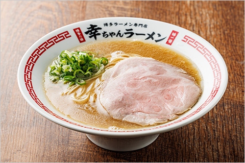 豚骨ラーメン(1杯) 1,000円  しっかりとした豚骨の旨味と、ほんのり感じる甘みがクセになるスープが特徴。麺は＜幸ちゃんラーメン＞の為だけに特別配合したこだわりの小麦粉を使用。＜幸ちゃんラーメン＞オリジナルの豚骨スープに合うよう、特注の細麺を使用しています。 こだわりの、しっとりとした特製大判チャーシュー、シャキシャキの青ネギと食べることで、本場博多の町豚骨を感じていただけます。